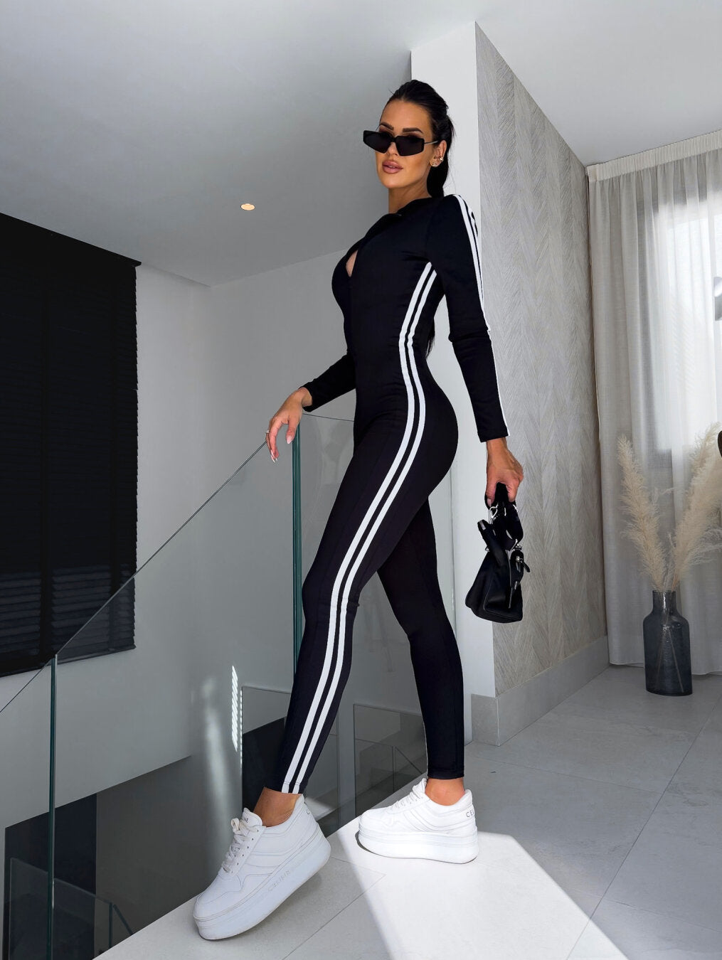 Eva - Combinaison sportive noire avec des rayures blanches sur les côtés